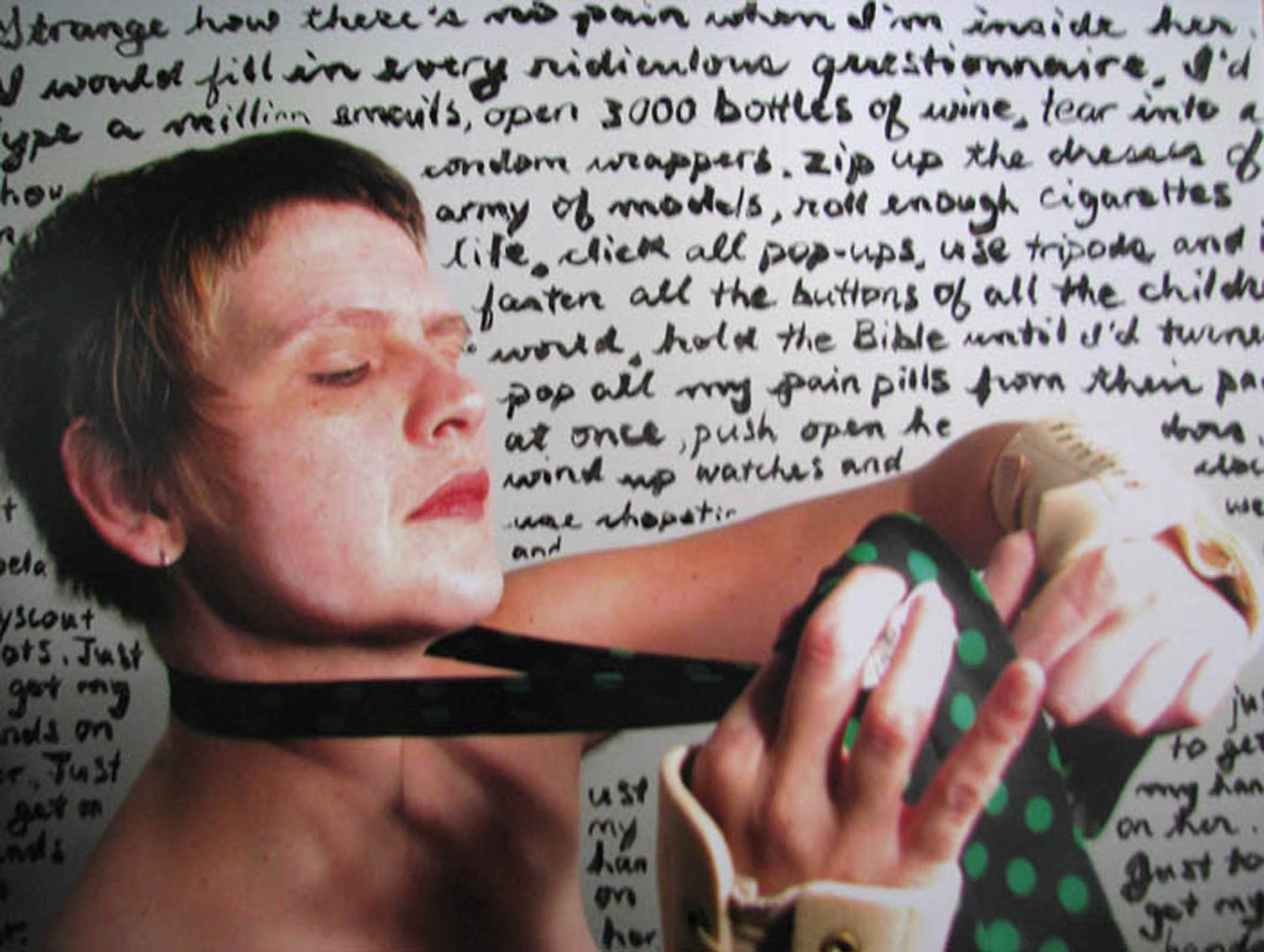 A photograph of multi-disciplinary artist Sandra Alland from above their bare chest. They are white with short brown hair. San is tying a polka dot green and black tie while wearing wrist supports. San sits or stands against a backdrop of handwritten words that are somewhat cut off. Some of the words include: Strange how there's no pain when I'm inside her. I would fill in every ridiculous questionnaire, I'd type a million emails, open 300 bottles of wine, tear into a... condom wrappers, zip up the dresses of... army of models, roll enough cigarettes... life, click all pop-ups, use tripods and... fasten all the buttons of all the chidren... world, hold the Bilbe until I'd turn... pop all my pain pill sfrom their...